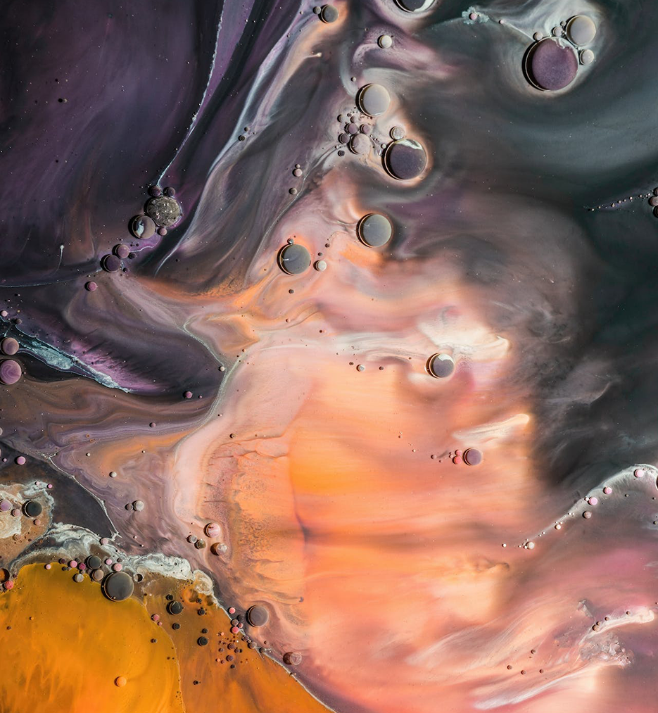 Abstract graphics with yellow, peach, blue and purple liquids containing small bubbles